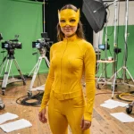 Actrice en costume de Fantômette sur le plateau de tournage de la série TV, entourée de matériel de production cinématographique